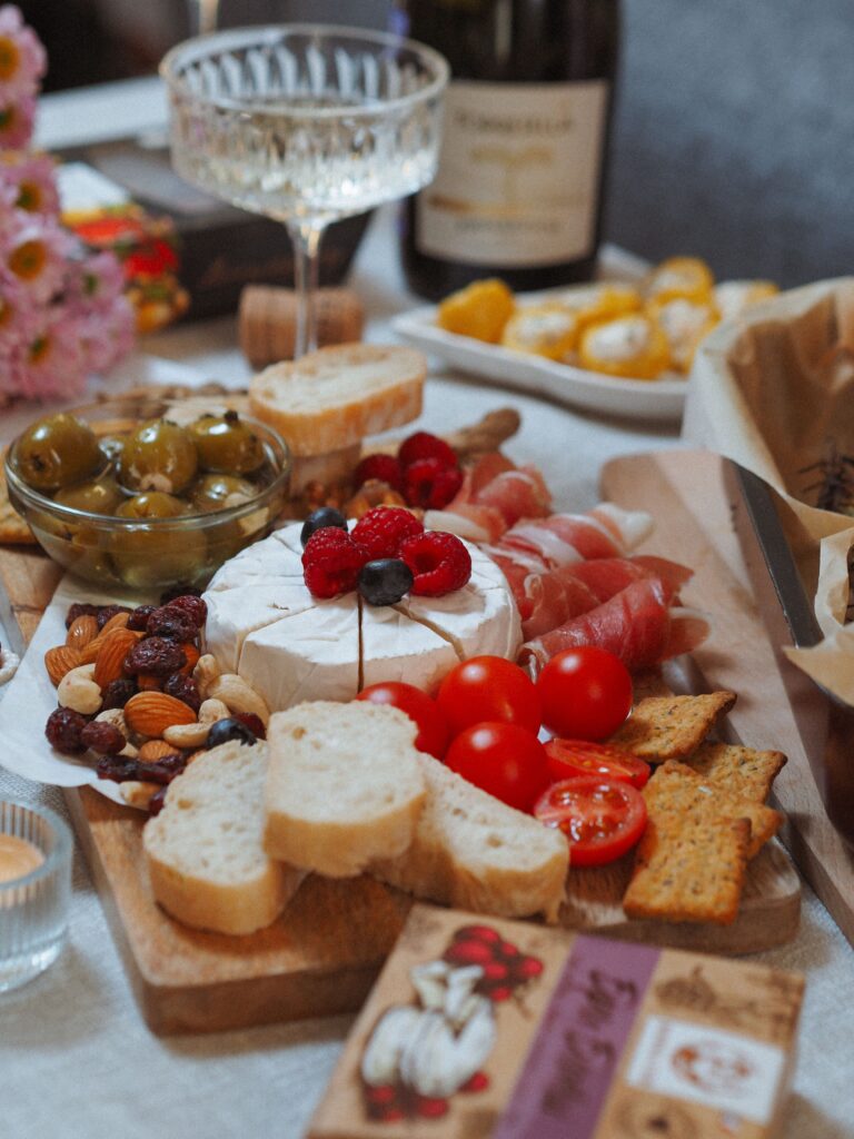 pexels photo 11406465 11406465 Delicious charcuterie board featuring cheese, ham, olives, and wine, perfect for gatherings.