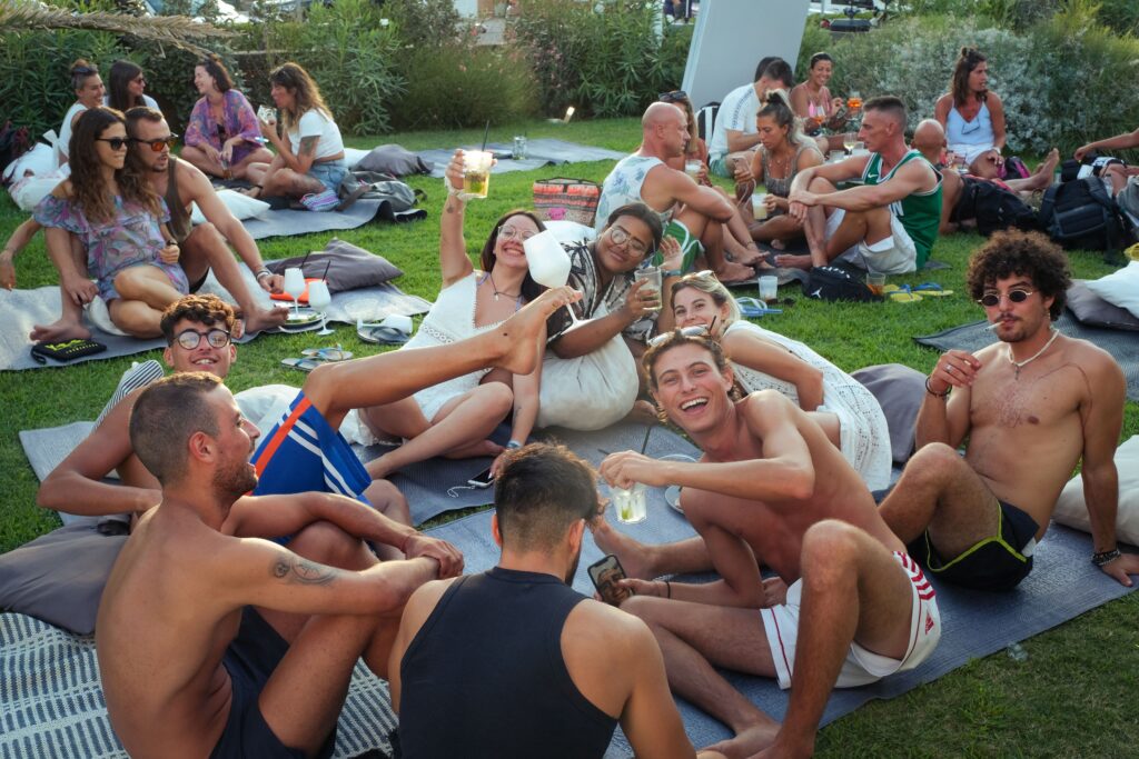 pexels photo 13301163 13301163 Group enjoying an outdoor summer party in Cervia, Italy, with laughter and drinks.