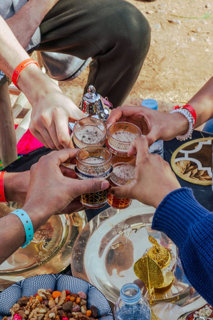 pexels photo 30874769 30874769 Five people toasting with Moroccan tea at an outdoor setting in Marrakesh.