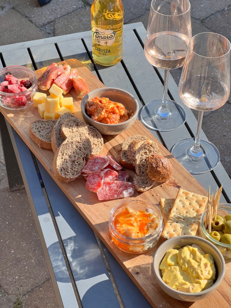pexels photo 38070349 38070349 A delicious charcuterie board with assorted meats, cheeses, bread, and wine on an outdoor table.